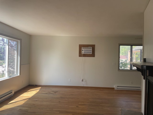 unfurnished living room with dark hardwood / wood-style flooring, a wall unit AC, and baseboard heating