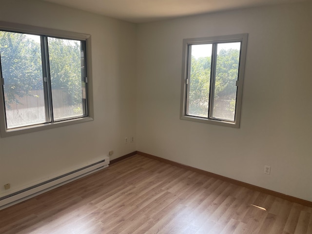 empty room with light hardwood / wood-style floors and baseboard heating