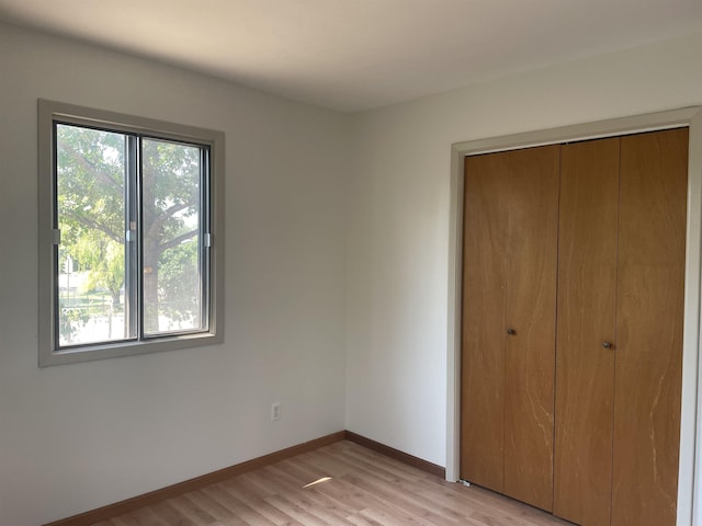 unfurnished bedroom featuring a closet and light hardwood / wood-style flooring