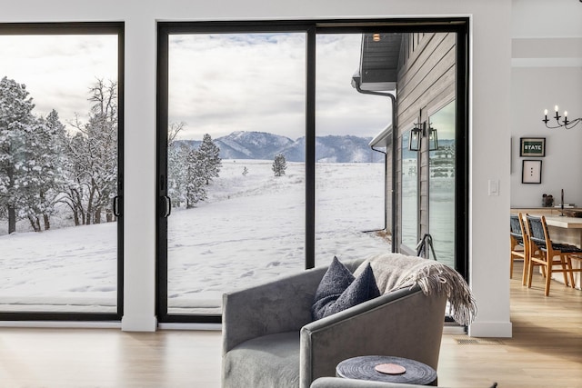 entryway featuring hardwood / wood-style floors, a mountain view, and a notable chandelier