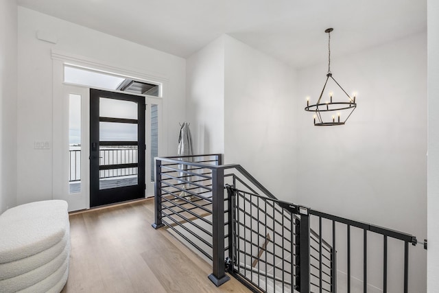 foyer with hardwood / wood-style flooring and an inviting chandelier