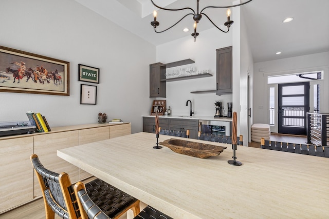 kitchen with dark brown cabinets, sink, wine cooler, and an inviting chandelier