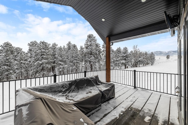 snow covered deck with a mountain view