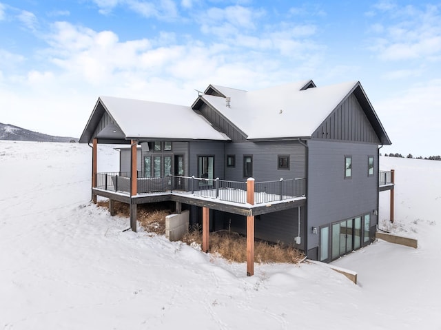 snow covered back of property with a garage