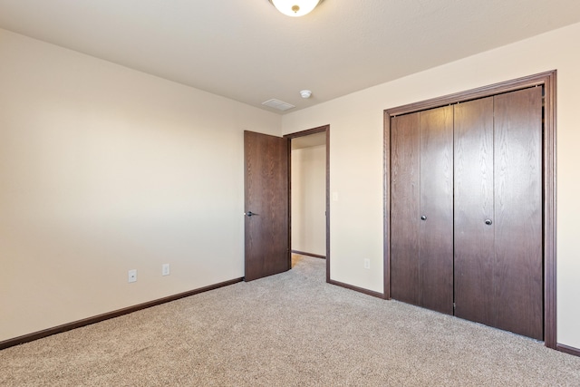 unfurnished bedroom with light carpet and a closet