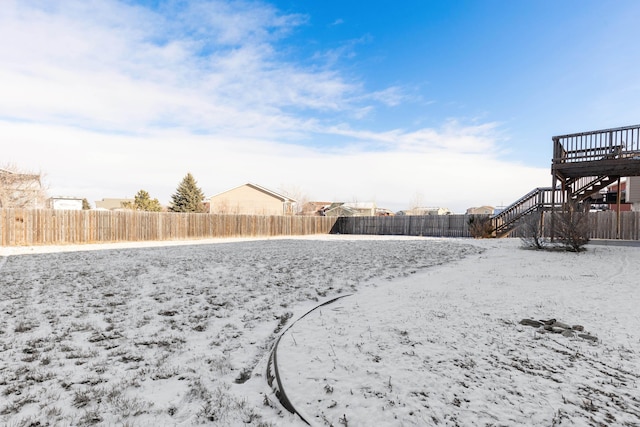 yard layered in snow featuring a deck