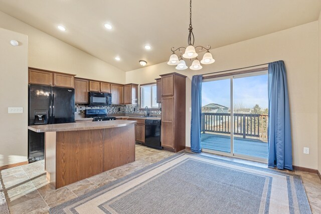 kitchen featuring an inviting chandelier, tasteful backsplash, pendant lighting, a kitchen island, and black appliances