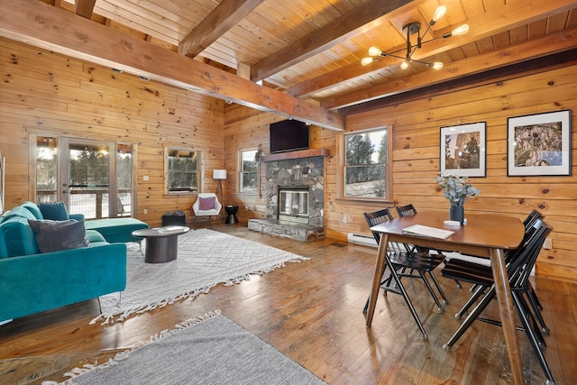 dining room with a fireplace, wooden ceiling, a notable chandelier, beamed ceiling, and hardwood / wood-style floors