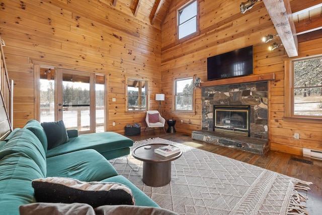 living room featuring a fireplace, wood ceiling, wooden walls, wood-type flooring, and beamed ceiling