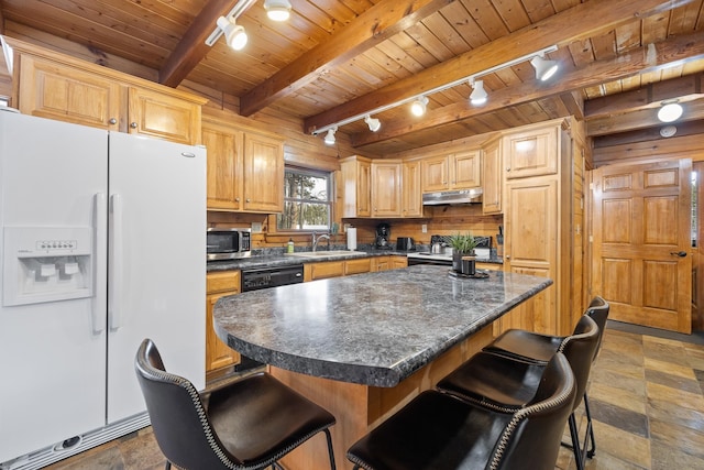 kitchen featuring a kitchen bar, rail lighting, sink, a center island, and white fridge with ice dispenser