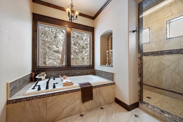 bathroom with an inviting chandelier, ornamental molding, and shower with separate bathtub