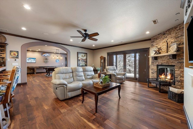 living room with a textured ceiling, ceiling fan, dark wood-type flooring, billiards, and a fireplace