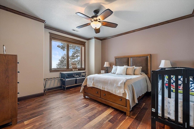 bedroom with a textured ceiling, ceiling fan, dark hardwood / wood-style floors, and ornamental molding