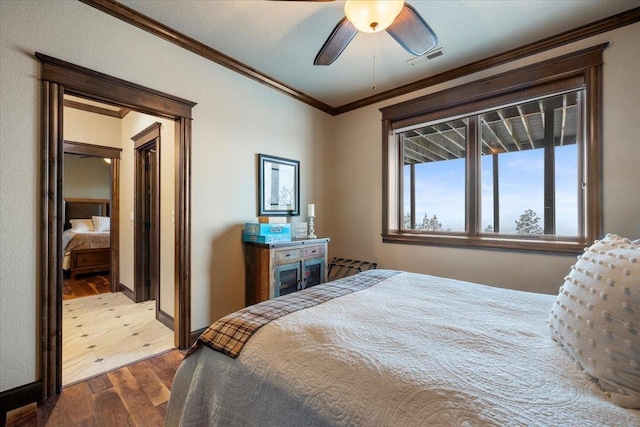 bedroom featuring hardwood / wood-style floors, ceiling fan, and crown molding