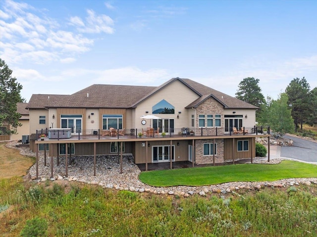 back of house featuring a lawn and a deck