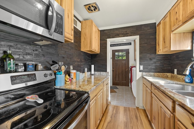 kitchen featuring light brown cabinetry, light stone counters, crown molding, sink, and black range with electric stovetop