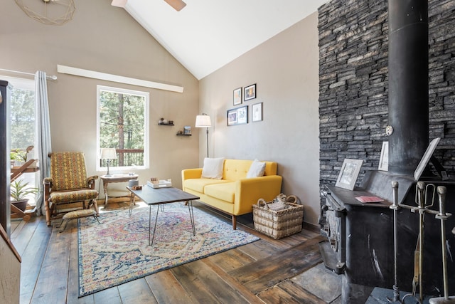 living room featuring hardwood / wood-style flooring, a wood stove, ceiling fan, and lofted ceiling