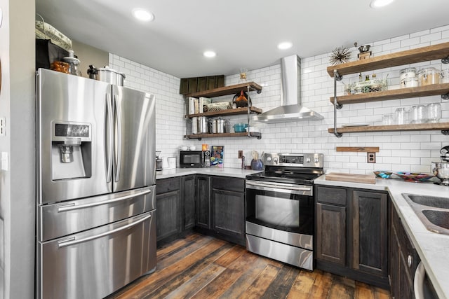 kitchen featuring wall chimney exhaust hood, dark hardwood / wood-style flooring, decorative backsplash, and appliances with stainless steel finishes