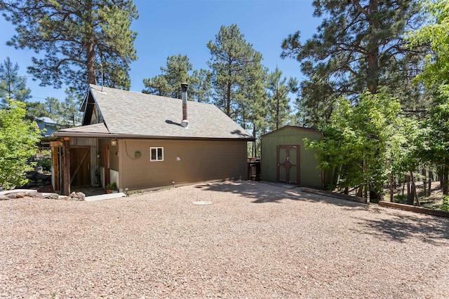 back of house featuring a shed