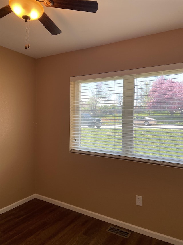 spare room with ceiling fan and dark wood-type flooring