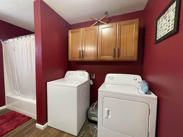 clothes washing area featuring cabinets, dark hardwood / wood-style flooring, washer and dryer, and a textured ceiling