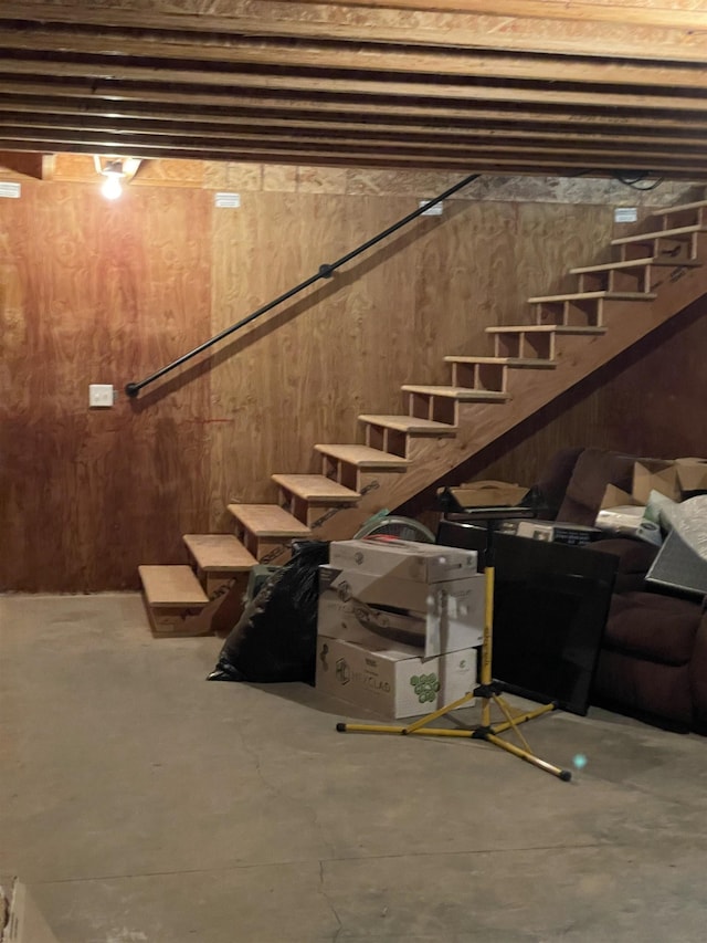 basement featuring wood walls