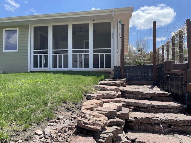 rear view of property featuring a lawn and a sunroom