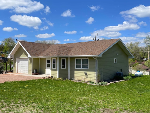 ranch-style house featuring a garage and a front lawn