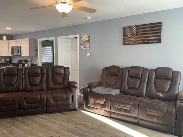 living room featuring ceiling fan and light wood-type flooring