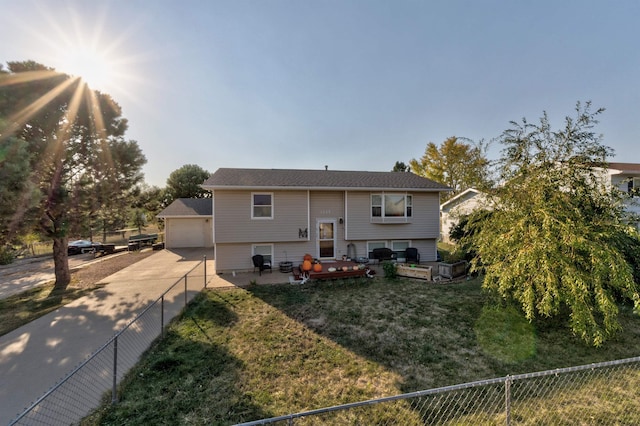 view of front of home featuring a wooden deck, a front yard, and a garage