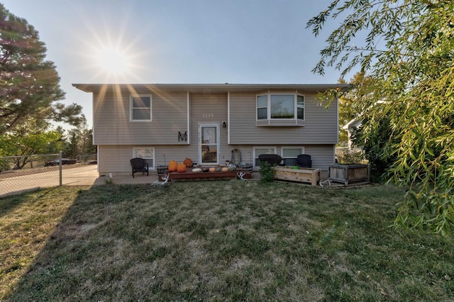 rear view of house featuring a lawn and a wooden deck