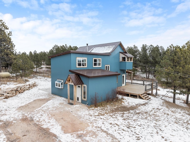 snow covered property featuring a balcony and a deck