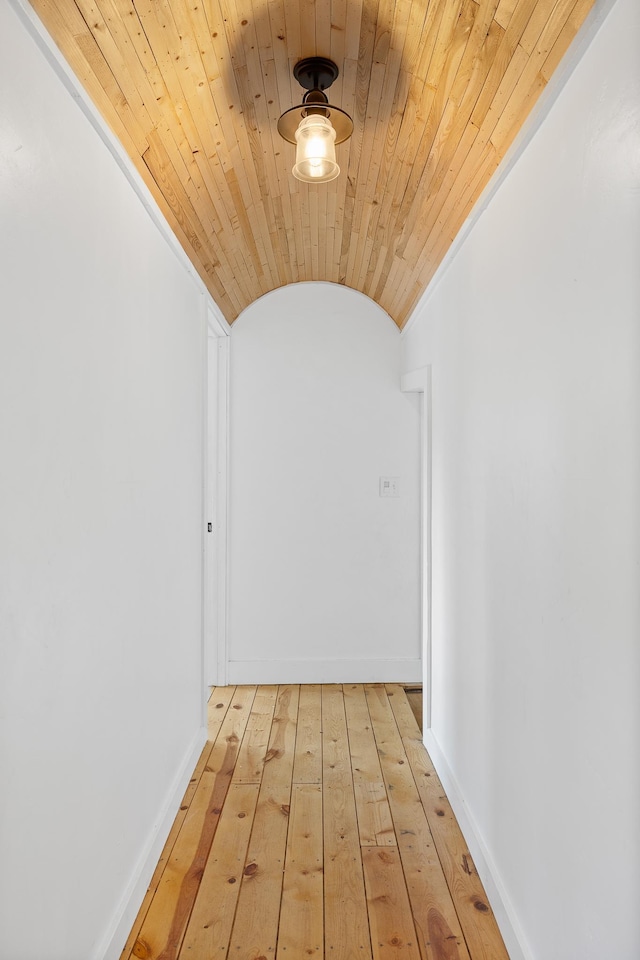 corridor with light wood-type flooring, wood ceiling, vaulted ceiling, and baseboards