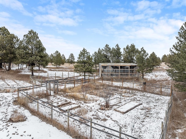 yard layered in snow featuring a rural view and fence