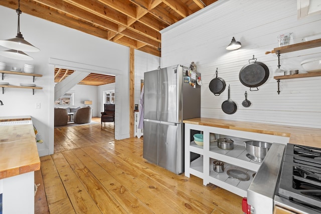 kitchen featuring wood counters, pendant lighting, freestanding refrigerator, light wood-type flooring, and open shelves