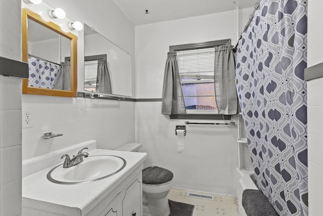 full bathroom featuring tile walls, vanity, shower / bath combo, and toilet