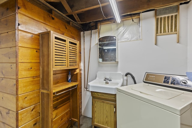 clothes washing area featuring sink and washer / dryer