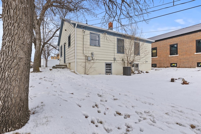 snow covered back of property with cooling unit