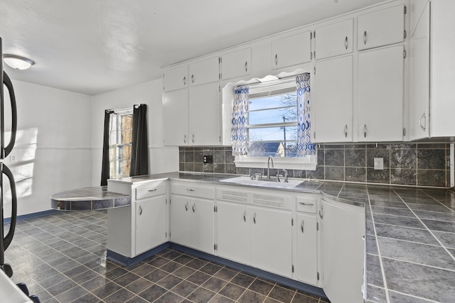 kitchen with white cabinets, backsplash, and dishwasher