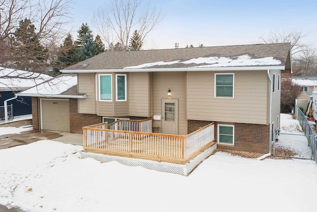 snow covered back of property with a garage