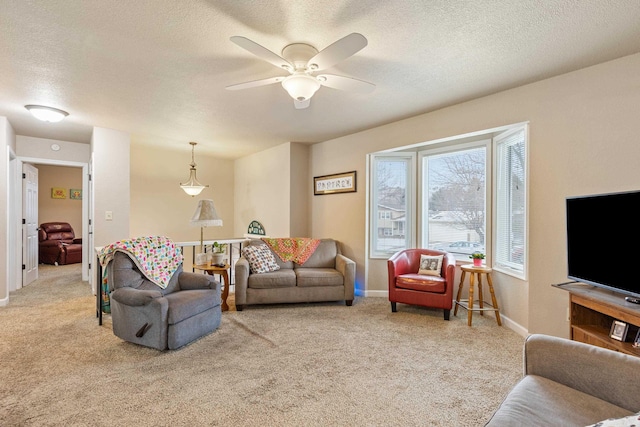 carpeted living room with ceiling fan and a textured ceiling