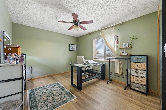 office featuring ceiling fan, light hardwood / wood-style floors, and a textured ceiling