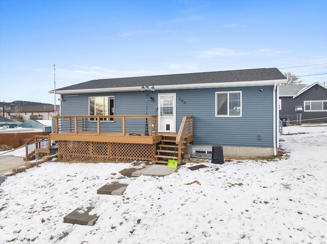 snow covered house featuring a deck