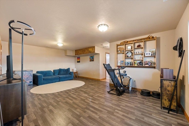 workout area with hardwood / wood-style floors and a textured ceiling