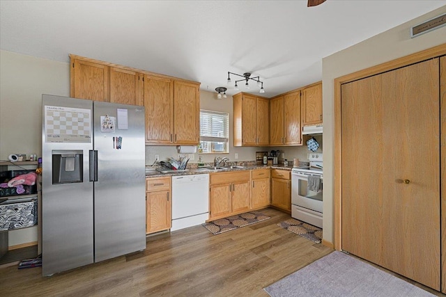 kitchen featuring sink, white appliances, and light wood-type flooring