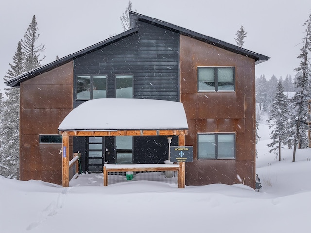 view of snow covered back of property