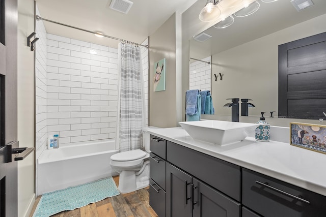 full bathroom featuring shower / bath combo with shower curtain, toilet, vanity, and hardwood / wood-style flooring