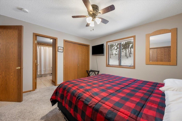 bedroom with ceiling fan, light colored carpet, and a textured ceiling