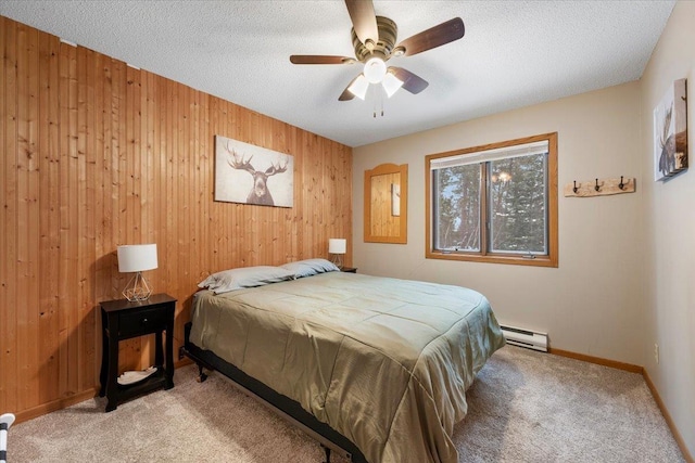 bedroom with ceiling fan, wooden walls, light carpet, and a baseboard heating unit