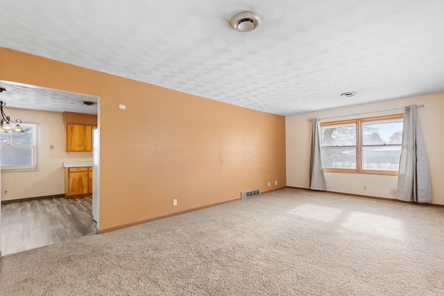 empty room featuring a textured ceiling and carpet flooring